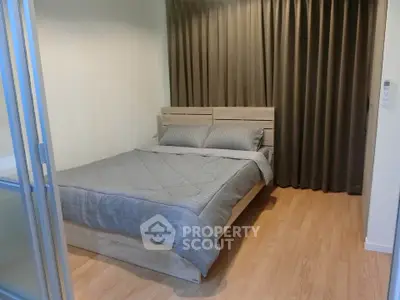 Cozy bedroom with wooden flooring and modern bed, perfect for relaxation.