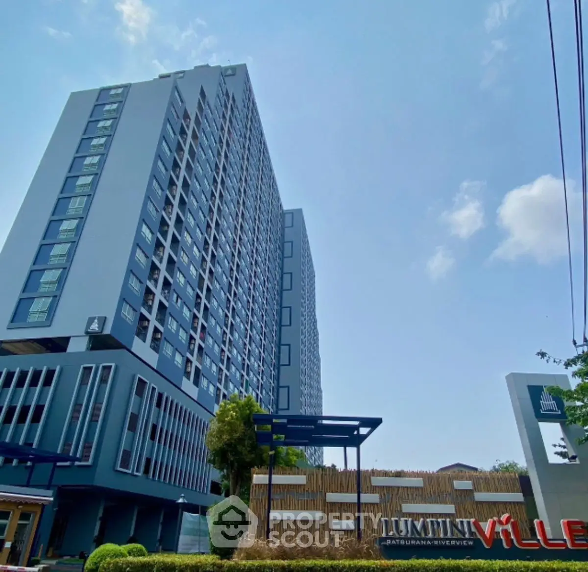 Modern high-rise building with clear blue sky, showcasing urban living at its finest.