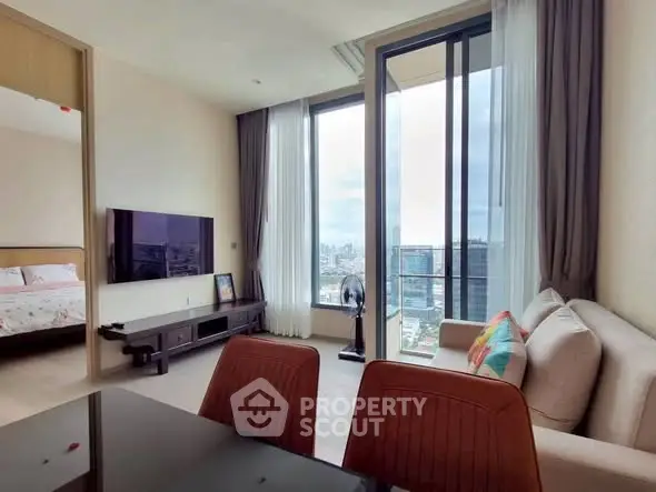 Modern living room with city view, large windows, and stylish furniture.