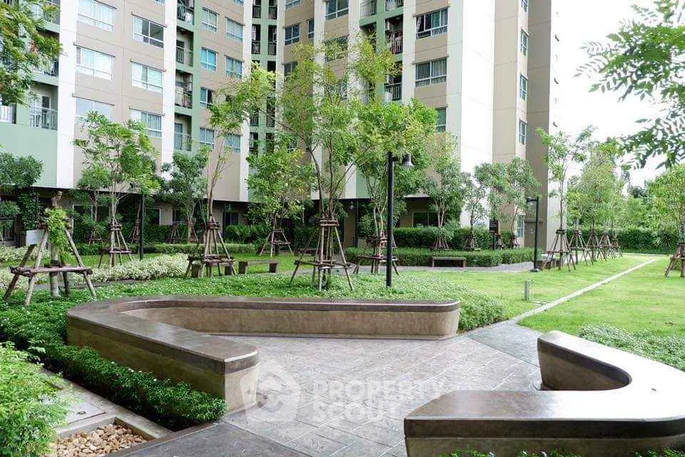 Modern apartment building with lush garden and seating area