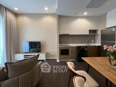 Modern open-plan living room with sleek kitchen and cozy seating area.