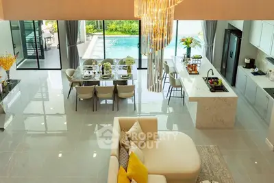 Luxurious open-plan living room with pool view and elegant kitchen island.