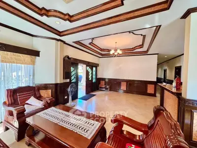 Elegant living room with wooden furniture and intricate ceiling design