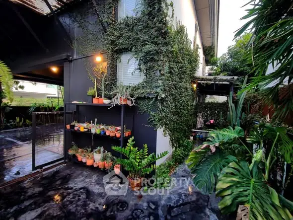 Charming garden view with lush greenery and potted plants in a modern home exterior.