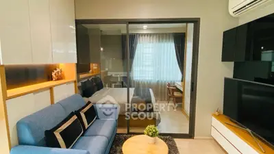 Modern studio apartment with cozy living area and bedroom separated by glass doors.