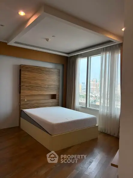 Spacious bedroom with large window offering city views, featuring modern design and wooden flooring.