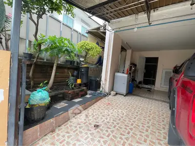 Spacious garage with tiled flooring and garden view, perfect for storage and parking needs.