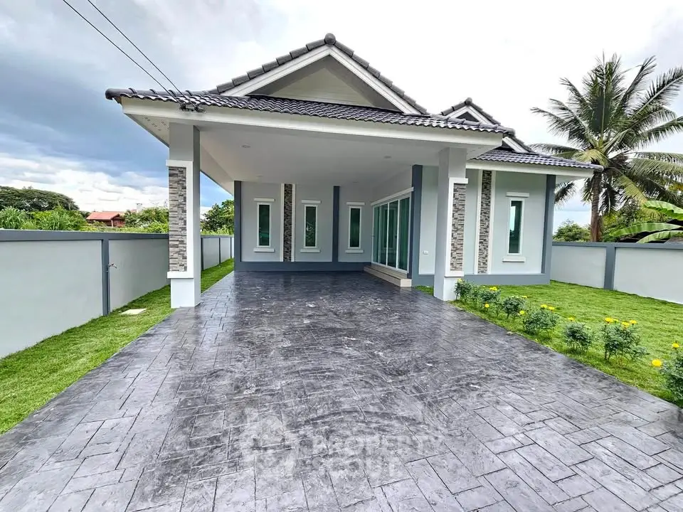 Modern single-story house with spacious driveway and lush garden, perfect for family living.