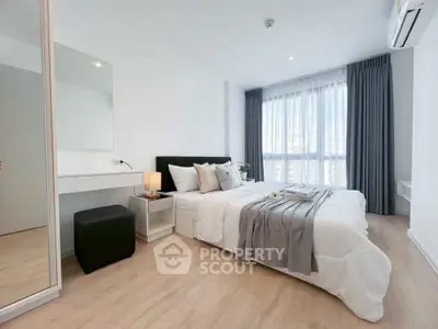 Modern bedroom with stylish decor and large window for natural light