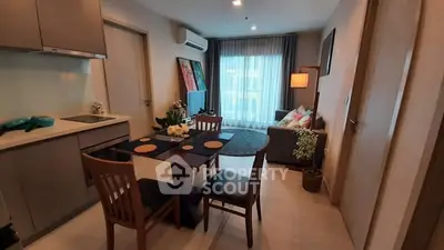 Modern open-layout kitchen and living room with stylish decor and natural light.