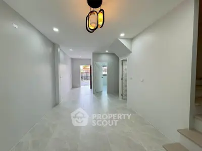 Spacious modern interior with sleek tile flooring and contemporary lighting, ideal for open living space.