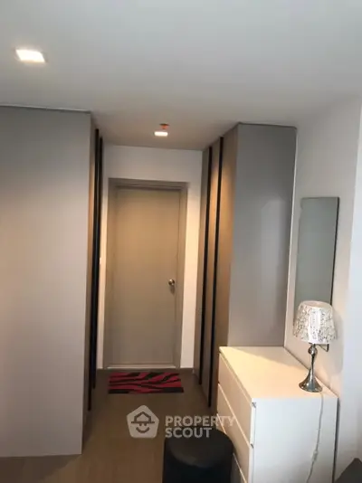 Modern hallway with sleek storage and elegant decor in a contemporary apartment.