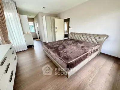 Spacious bedroom with elegant bed and wooden flooring in modern home