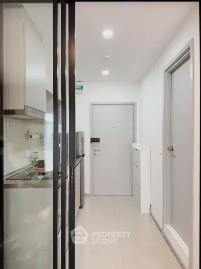 Modern apartment entrance with sleek kitchen and minimalist design