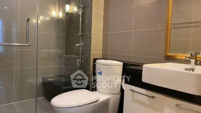 Modern bathroom with glass shower and sleek fixtures in elegant real estate property.