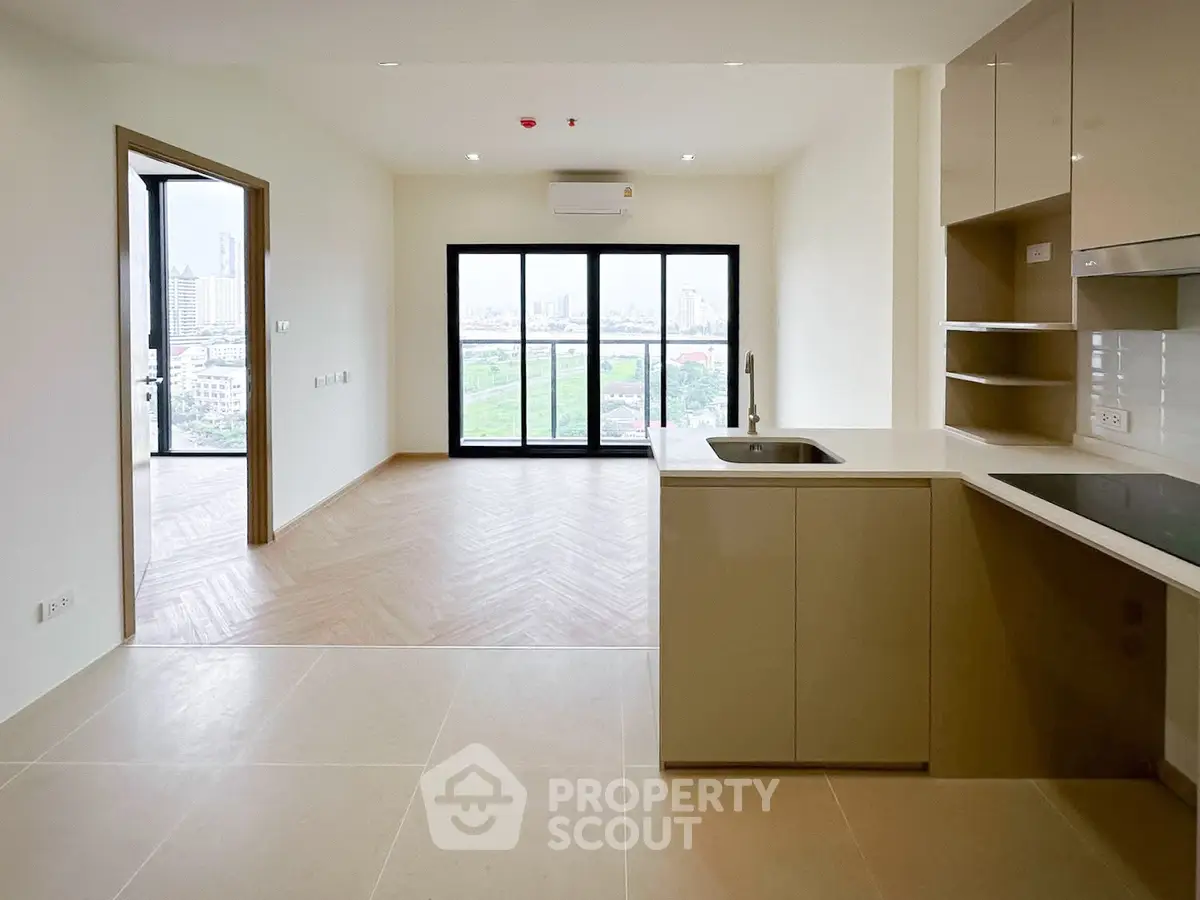 Modern open-plan kitchen and living room with large windows and city view.