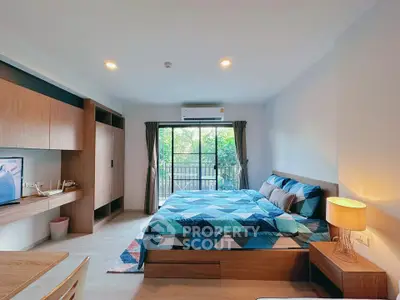 Modern bedroom with stylish decor and large window overlooking greenery