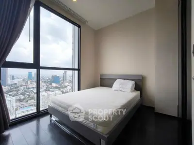Modern bedroom with large window offering stunning city views, featuring a minimalist bed and dark wood flooring.