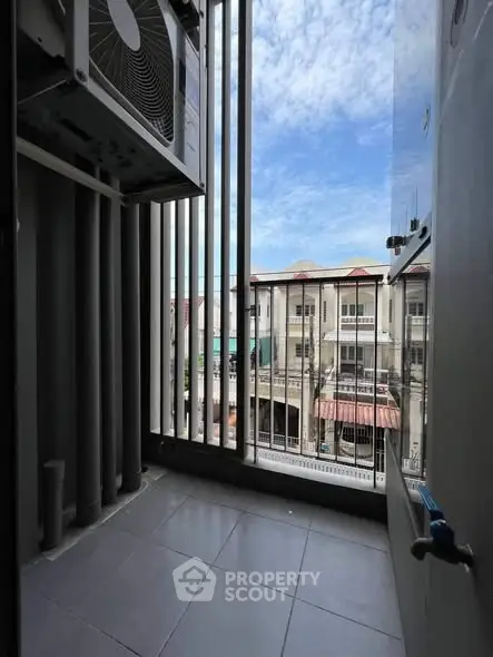 Compact balcony with city view and air conditioning unit