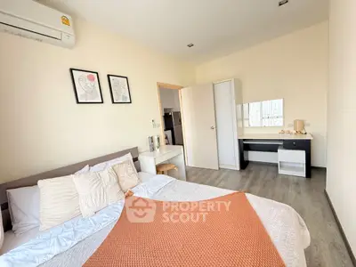 Modern bedroom with stylish decor and ample natural light, featuring a cozy bed and sleek furniture.