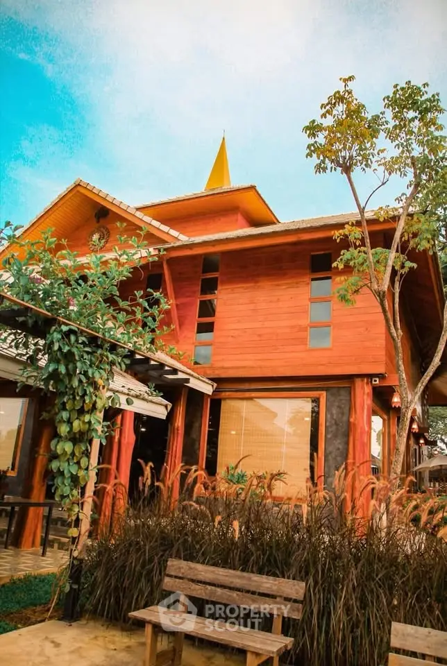 Charming wooden house with lush garden and rustic bench, perfect for serene living.