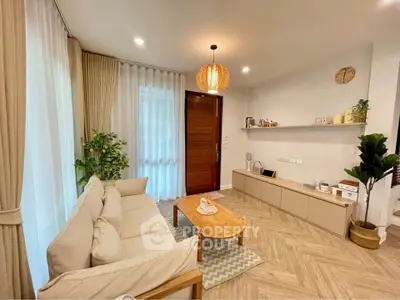 Stylish living room with modern decor and natural light, featuring cozy seating and elegant wooden accents.