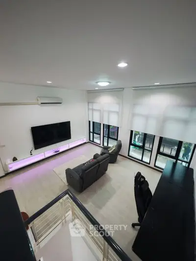 Spacious modern living room with large windows and stylish furniture, perfect for relaxation and entertainment.