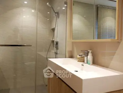 Modern bathroom with sleek shower and stylish vanity in contemporary home.