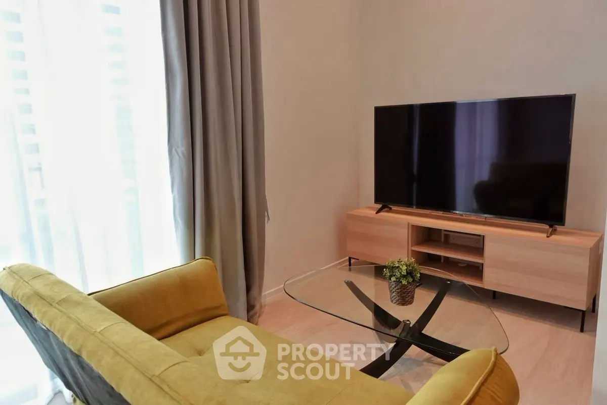 Modern living room with stylish furniture and large TV, perfect for relaxation and entertainment.
