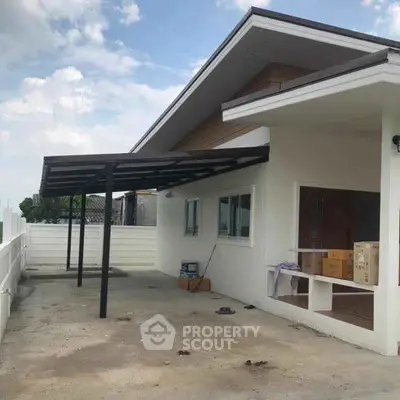 Modern single-story house with spacious covered patio and sleek roof design.