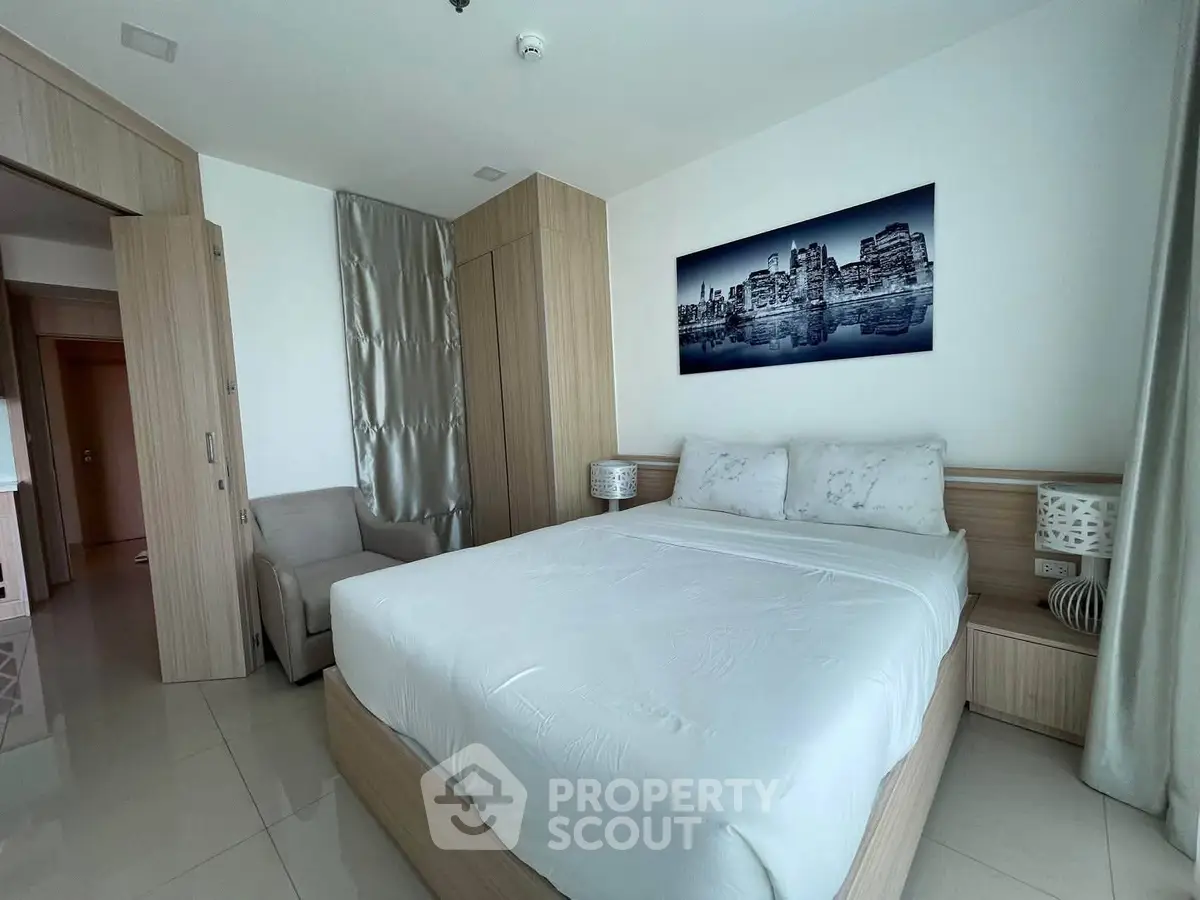 Modern bedroom with sleek design and cityscape artwork, featuring a comfortable bed and elegant decor.