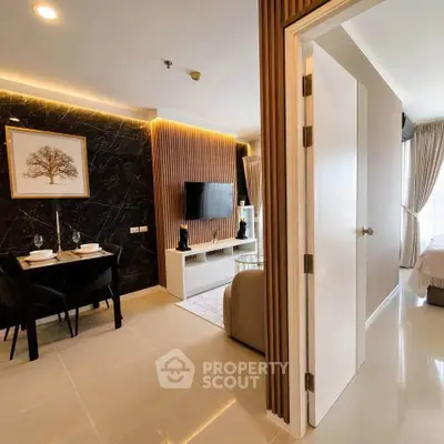 Modern open-plan living room with elegant decor and partial bedroom view in luxury apartment.