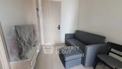 Cozy living room with modern gray sofa and flat-screen TV in compact apartment.