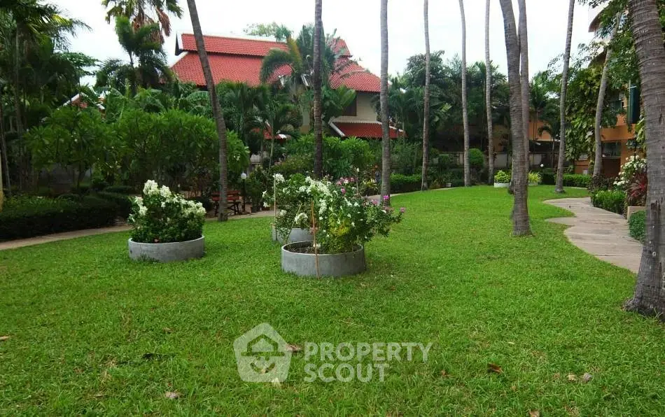 Lush tropical garden with vibrant greenery and palm trees in a serene residential setting.