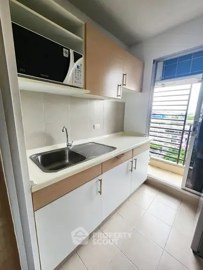 Modern kitchen with sleek cabinetry and a scenic balcony view, perfect for urban living.