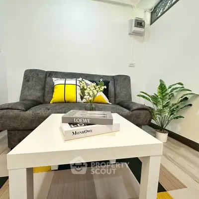 Modern living room with stylish sofa, vibrant cushions, and elegant decor in a cozy apartment setting.