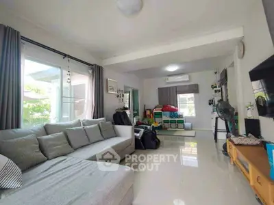 Spacious living room with modern gray sofa and large windows in a bright, airy home.