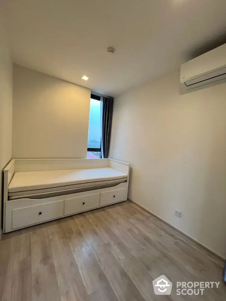 Cozy bedroom with minimalist design featuring a daybed and air conditioning.