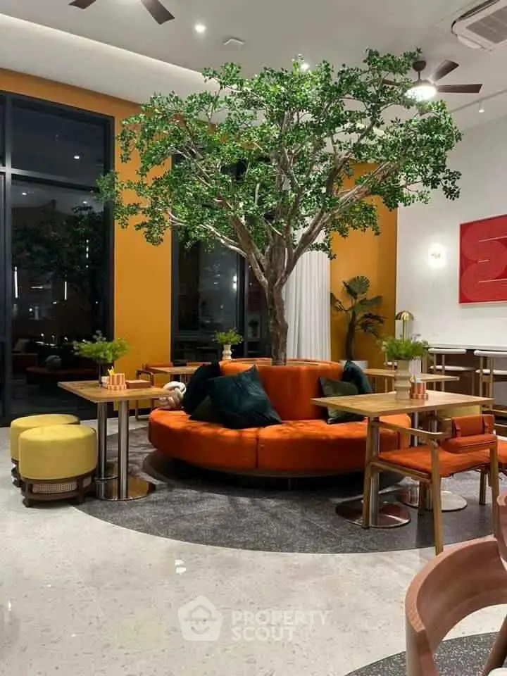 Modern living room with stylish orange seating and indoor tree centerpiece