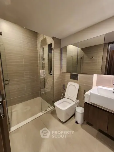 Modern bathroom with glass shower and sleek fixtures in a contemporary home.