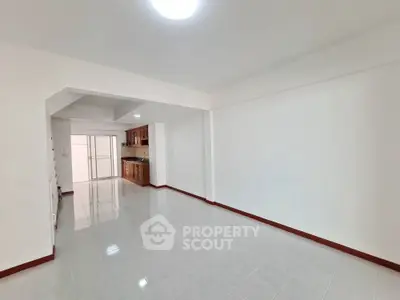 Spacious open-plan living area with tiled flooring and modern kitchen.