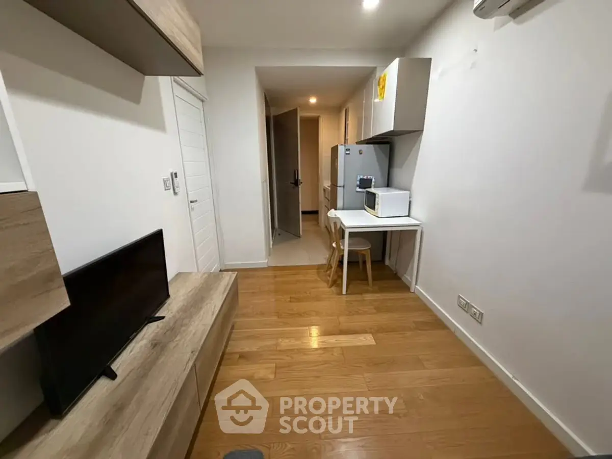 Modern compact living space with wooden flooring and sleek furniture