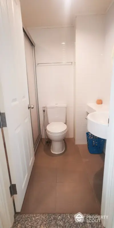 Compact bathroom with modern fixtures and neutral tiles