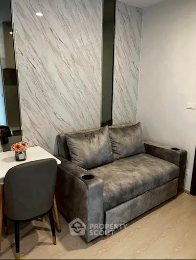 Modern living room with stylish gray sofa and marble accent wall