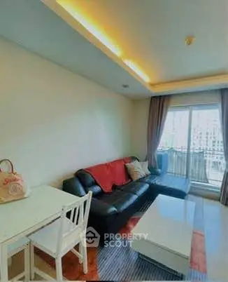 Modern living room with stylish sofa and large window offering natural light and city view.