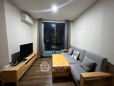 Modern living room with sleek furniture and city view balcony.