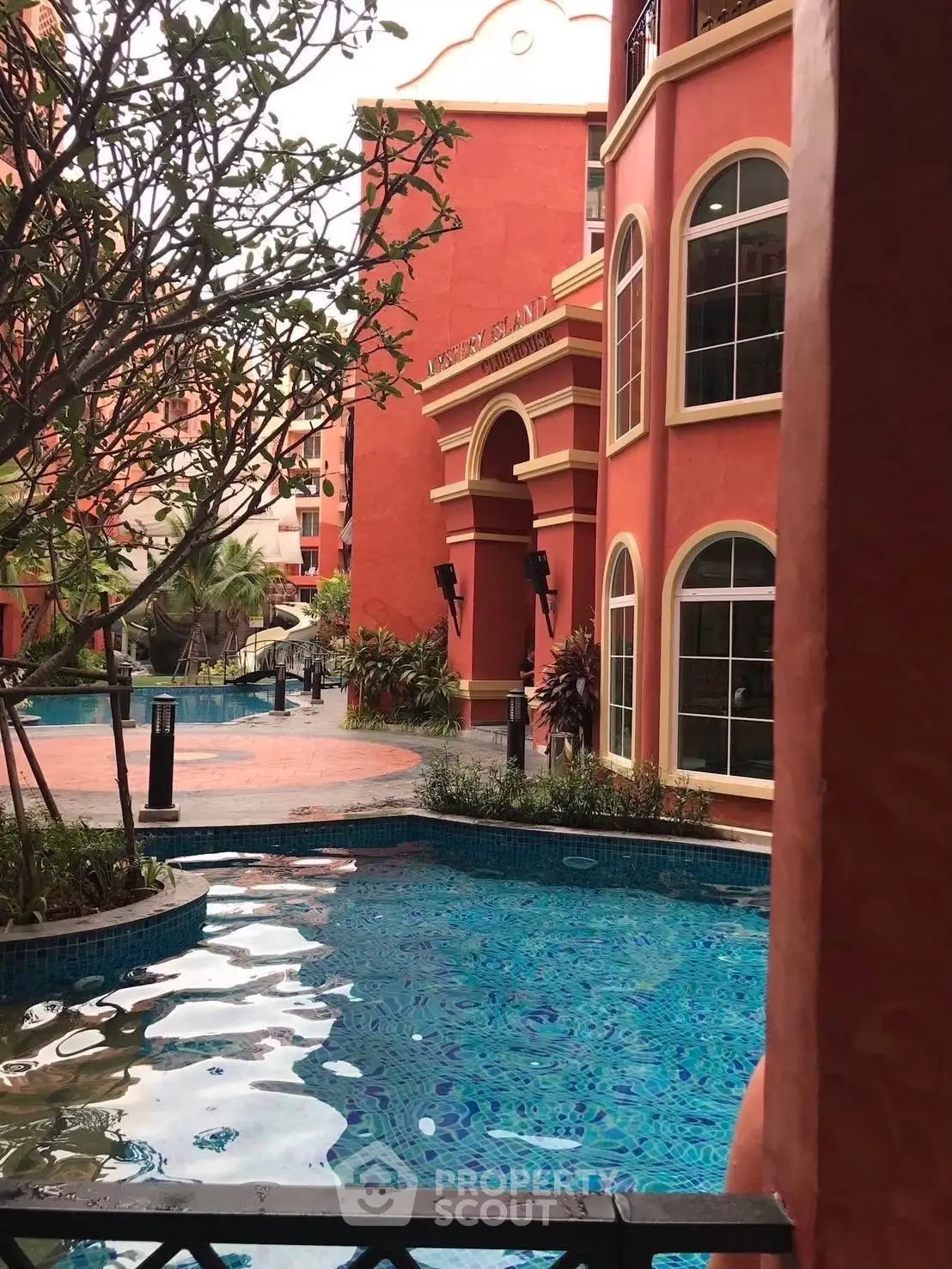 Stunning poolside view at luxurious residential complex with vibrant architecture.