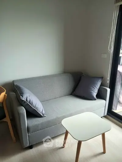 Cozy living room with modern gray sofa and stylish wooden table, perfect for relaxation.