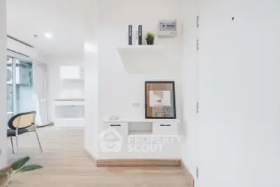 Modern minimalist interior with white walls, wooden flooring, and stylish shelving in a bright living space.