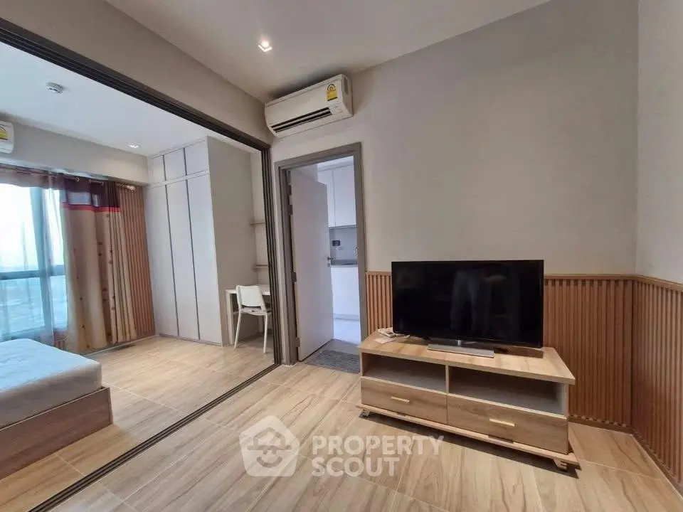 Modern apartment interior with open layout, featuring a cozy living area and adjacent bedroom.